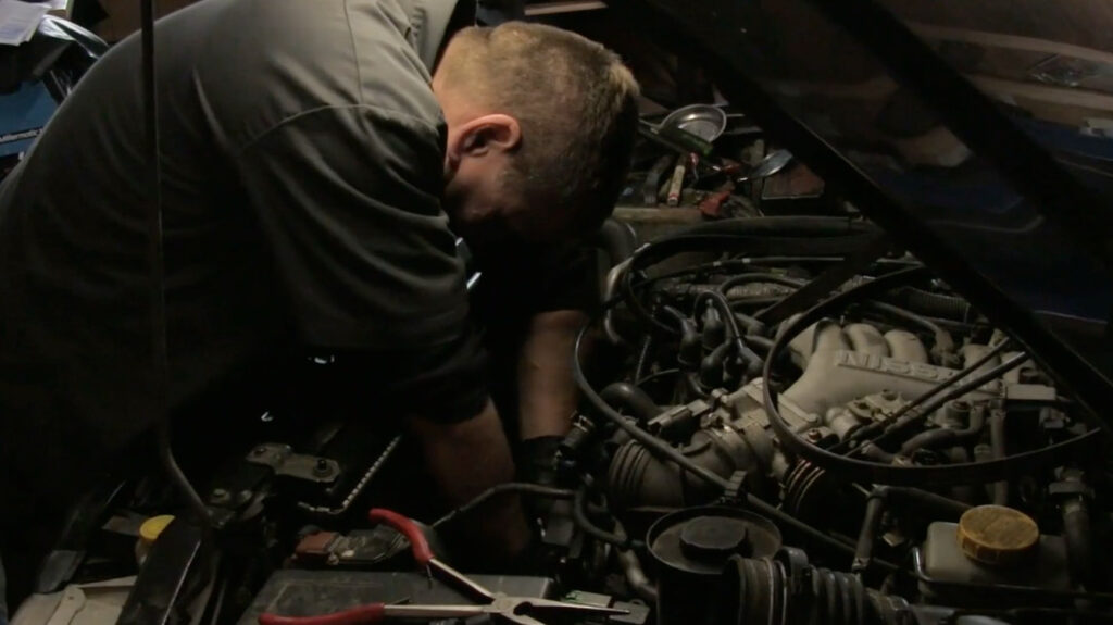 Mechanic making fixes to a car inside vehicle repair shop