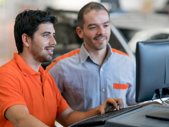 2 Men looking at Auto Repair Shop Data on computer
